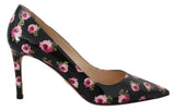 A single black patent leather pump with a pink rose floral print, featuring a pointed toe and a slim stiletto heel, shown against a plain white background.